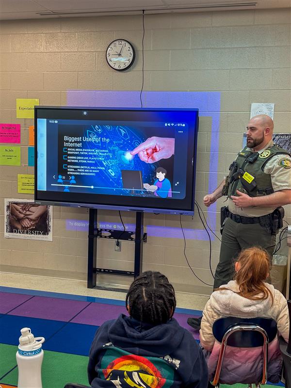 police officer talking to class of students